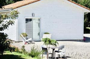 a white house with chairs and a table in front of it at gîte le Champ Libre in Dompierre-sur-Yon