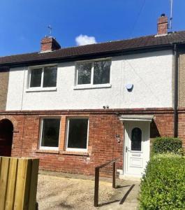 a white and red brick house with a white door at Modern 4 bed home, 30 minute walk from City Centre in York