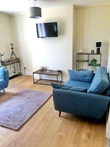 een woonkamer met een blauwe bank en een tafel bij Modern 4 bed home, 30 minute walk from City Centre in York