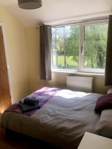 a bed in a bedroom with a large window at Modern 4 bed home, 30 minute walk from City Centre in York