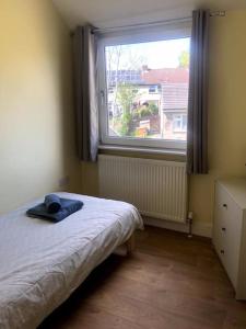 a bedroom with a bed and a large window at Modern 4 bed home, 30 minute walk from City Centre in York