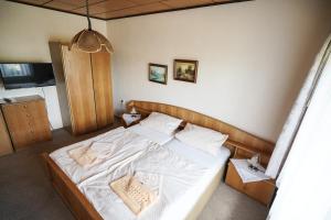 una camera da letto con letto, lenzuola e cuscini bianchi di Gasthof Zum Goldenen Stern a Karstädt