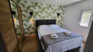 a small bedroom with a bed with towels on it at Villa Accordo in Vinišće