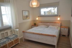 1 Schlafzimmer mit einem weißen Bett und 2 Fenstern in der Unterkunft Hoeri Ferienhaus -Lake Constance in Öhningen