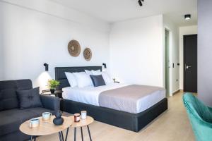 a bedroom with a bed and a couch at Nerea Boutique Suites Karystos in Karistos