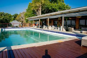 a swimming pool in front of a house at Rorkes Drift Lodge in Rorkeʼs Drift