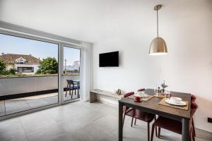 uma sala de estar com uma mesa de jantar e uma varanda em Apartments Curti - Abendrot em Laives