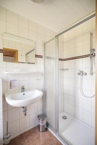 een witte badkamer met een wastafel en een douche bij Gasthof Zum Goldenen Stern in Karstädt