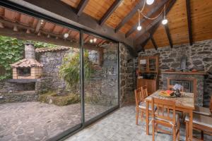 una cocina al aire libre con mesa y chimenea en Casa de Campo Arco de São Jorge by An Island Apart, en Santana