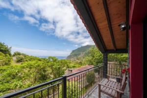 a balcony with a bench and a view of the ocean at Casa de Campo Arco de São Jorge by An Island Apart in Santana