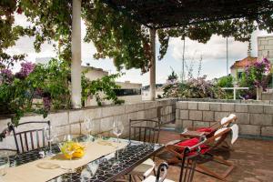 einen Tisch und Stühle mit Weingläsern auf der Terrasse in der Unterkunft Apartment Vent in Dubrovnik