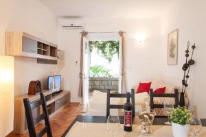 uma sala de estar com uma mesa com copos de vinho em Apartment Vent em Dubrovnik