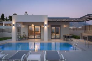 a villa with a swimming pool in front of a house at Eolides Villas , Quite Idyll of Rural Bliss,By ThinkVilla in Lambiní