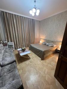1 dormitorio con cama, mesa y sofá en Georgian House, en Tiflis
