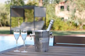 a bucket of champagne and two wine glasses on a table at Villa Regina Elena Vittoria in Porcari