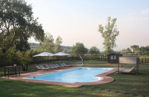 uma piscina com bancos e guarda-sóis num quintal em Villa Regina Elena Vittoria em Porcari