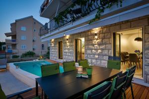 a patio with a table and chairs and a swimming pool at Villa Nika with private heated pool in Slano