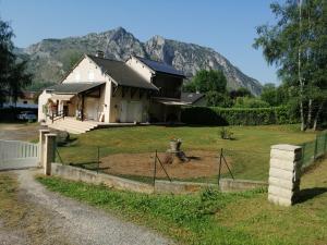 une maison avec une clôture et une montagne en arrière-plan dans l'établissement A LA JOIE DE VIVRE Chez l'habitant, à Banat