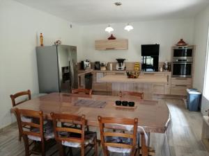 kuchnia z dużym drewnianym stołem i krzesłami w obiekcie A LA JOIE DE VIVRE Chez l'habitant w mieście Banat