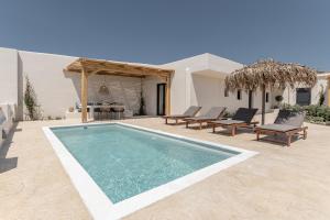 a swimming pool with chairs and a house at Golden Sand Villas with Private Pool in Vívlos