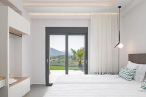 a bedroom with a bed with a view of the ocean at Eolides Villas a mythical escape in Lambiní +90 photos