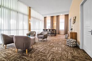 a hotel lobby with chairs and a table at TOSCANINA Garni Hotel in Dobrovo