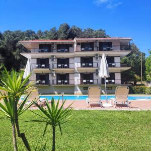 a large building with two chairs and a pool at Villa Dimitris in Parga