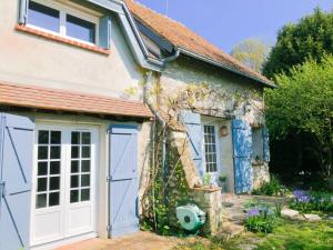 Cottage mit einer blauen Garagentür in der Unterkunft La samsonniére in Courbouzon