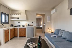a kitchen and a living room with a couch and a table at Golden Sand Villas with Private Pool in Vívlos