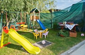 a playground with a slide and chairs and a table at Hostel Žganjer in Ozalj