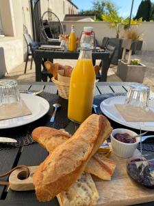 a table with bread and a bottle of orange juice at Le Domaine Des Sources in Saint-Martin-dʼAblois