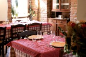 una mesa con un mantel rojo y gafas. en Agriturismo Le Selve, en Comunanza