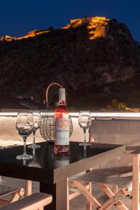 a bottle of wine sitting on a table with two wine glasses at Eudokia Pension in Nafplio