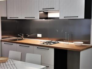 a kitchen with white cabinets and a wooden counter top at Mare & Laguna in Chioggia