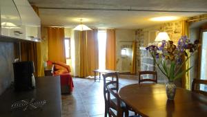 ein Wohnzimmer mit einem Tisch und einer Blumenvase darauf in der Unterkunft Gîte de Chapelèche Les Glycines in Gluiras
