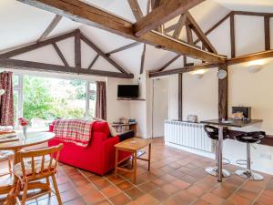 a living room with a red couch and a table at The Nest Box in Diss