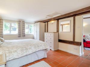 a bedroom with a bed and a dresser and windows at The Nest Box in Diss