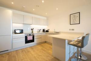 a kitchen with white cabinets and a counter top at Luxury beach apartment in Perranporth