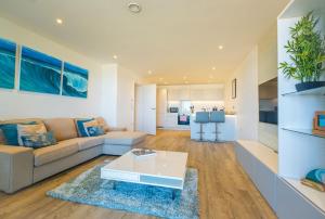 a living room with a couch and a table at Luxury beach apartment in Perranporth