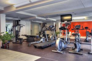 a gym with several tread machines and a flat screen tv at Hotel Forestel in Val-dʼOr