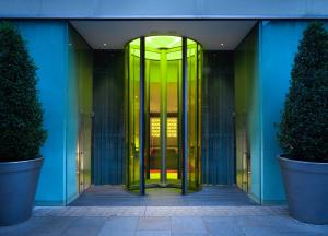 an entrance to a building with a yellow revolving door at St Martins Lane London in London