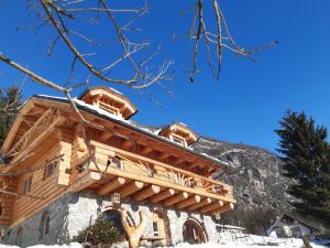 une maison en rondins avec une montagne en arrière-plan dans l'établissement Natur apartma Rudi, à Begunje na Gorenjskem