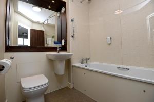 鄧巴的住宿－Pine Marten, Dunbar by Marston's Inns，浴室配有卫生间、盥洗盆和浴缸。