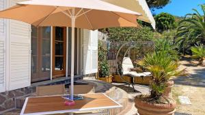 un tavolo con ombrellone su un patio di Villetta I Due Pini a Capoliveri