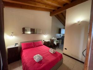 sypialnia z czerwonym łóżkiem w pokoju w obiekcie La FIOCCHINA - Magic Place - apartments & studios in Garda Lake - countryside farmhouse, inside the middle of the lake w mieście Salò