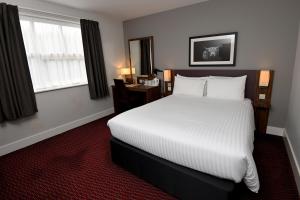a bedroom with a large white bed and a window at Pine Marten, Dunbar by Marston's Inns in Dunbar