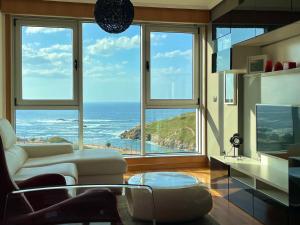 PARKING, vistas al MAR y tres habitaciones في لا كورونيا: غرفة معيشة مطلة على المحيط