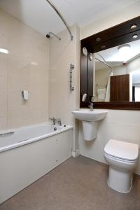 a bathroom with a sink and a tub and a toilet at Pine Marten, Dunbar by Marston's Inns in Dunbar