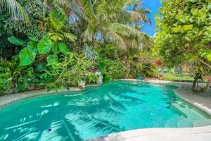 a swimming pool in a resort with palm trees at Flamingo Casita in West Palm Beach