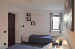 Habitación pequeña con cama y ventana en B&B Li Gutti en Aieta